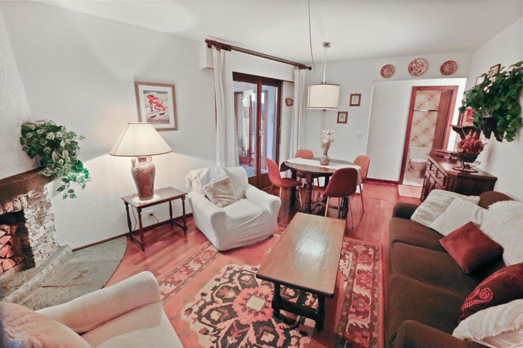 een woonkamer met een bank en een tafel bij Charmant appartement avec vue sur les montagnes in Crans-Montana