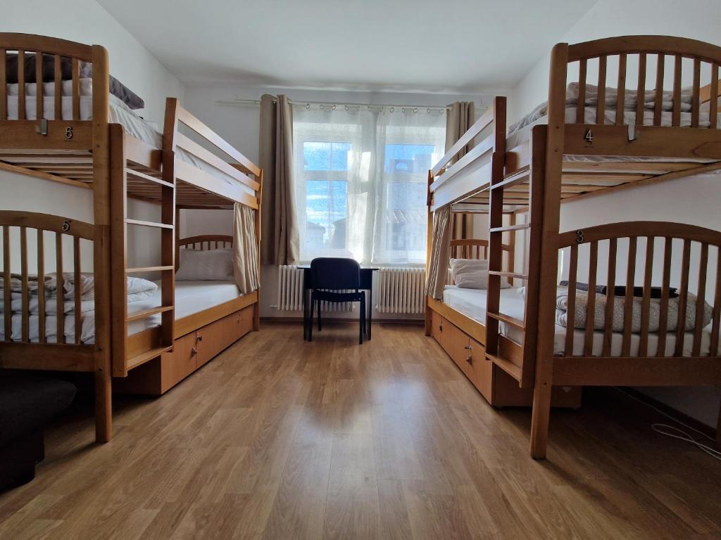 a room with four bunk beds and a chair at Hostel Andrei in Iaşi