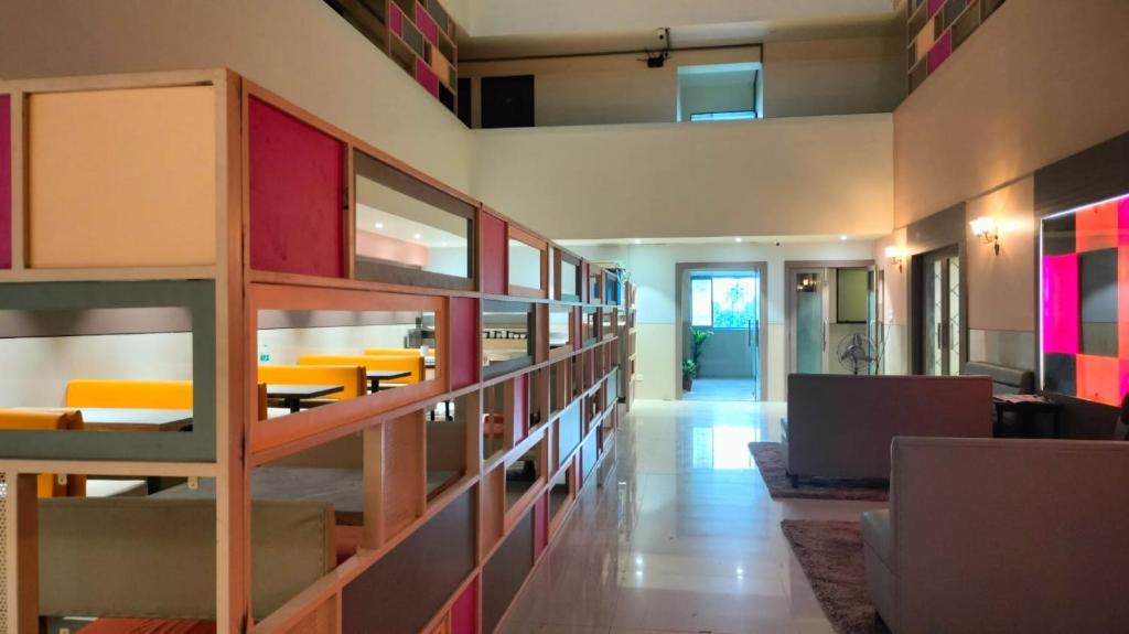 a room with a library with tables and a laptop at Hotel Sai Nidhi Executive-MindSpace Airoli Navi Mumbai in Navi Mumbai