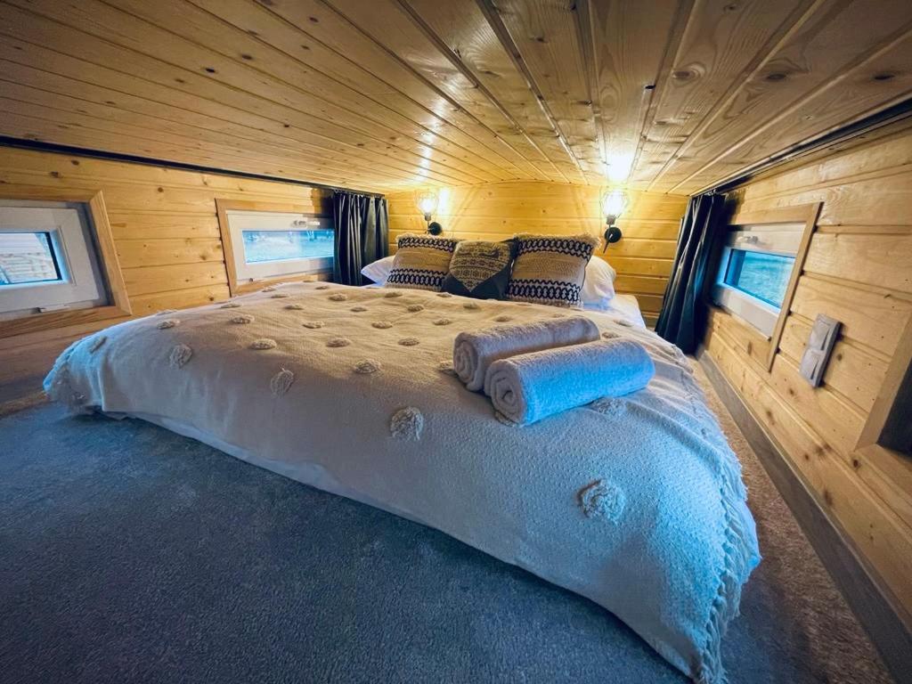 um quarto com uma cama grande num chalé de madeira em Tiny House Village (850m od Suntago) em Grabce