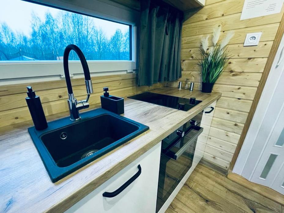 kuchnia ze zlewem w małym domku w obiekcie Tiny House Village (850m od Suntago) w mieście Grabce