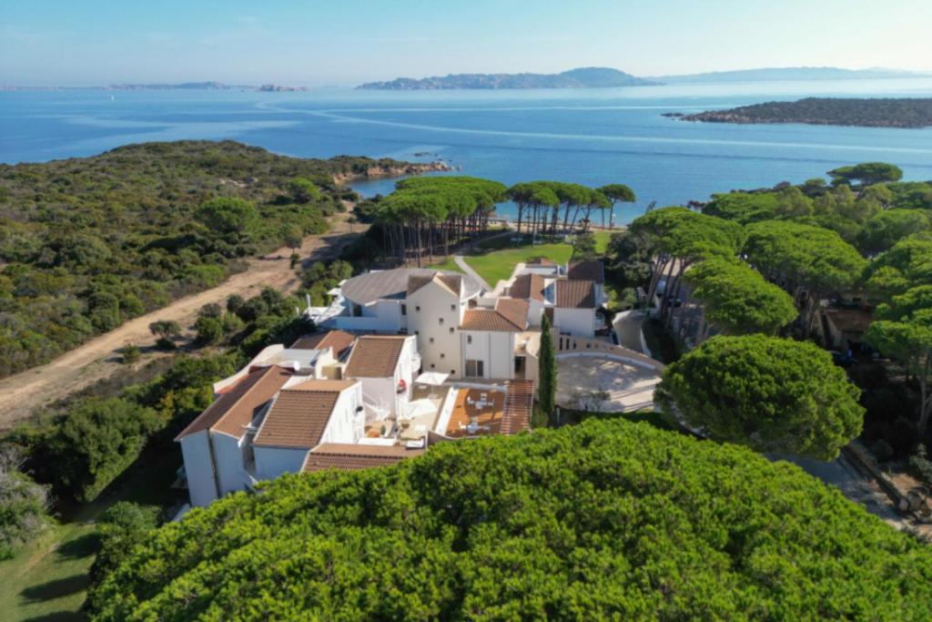 an aerial view of a house on a hill next to the water at La Coluccia in Santa Teresa Gallura