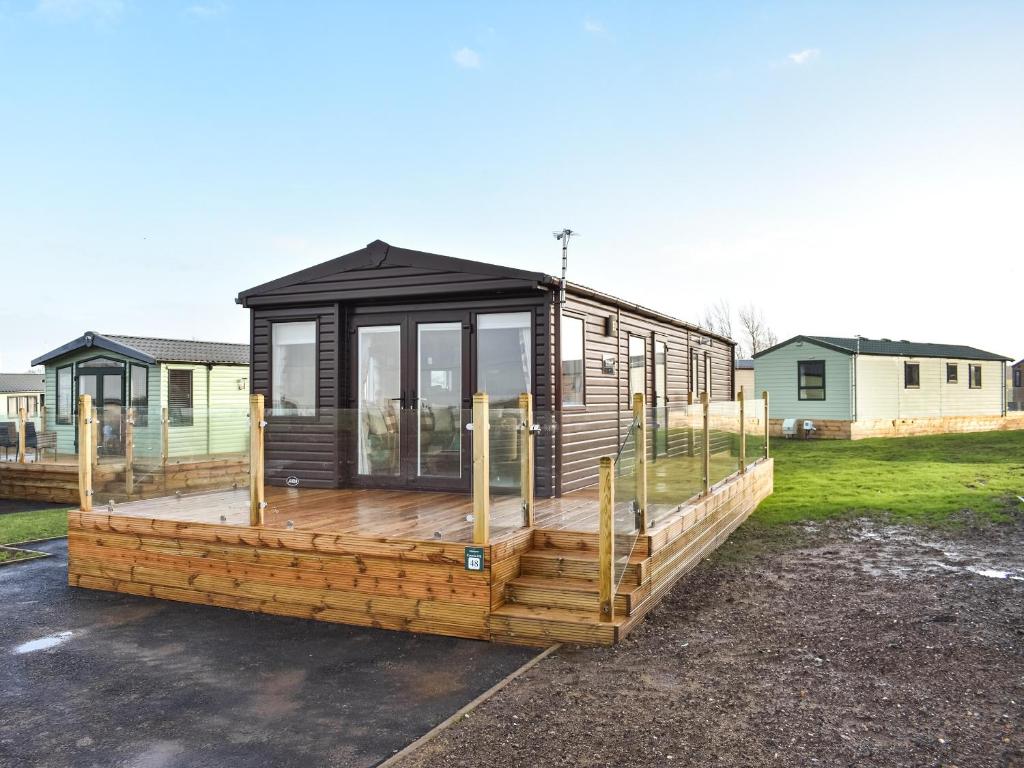 a large wooden house with a large deck at Solway View in Plumbland