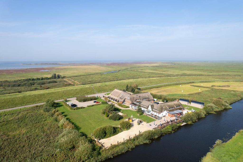 eine Luftansicht eines Hauses auf einer Insel in einem Fluss in der Unterkunft Nordsee-Hotel Arlau-Schleuse in Husum