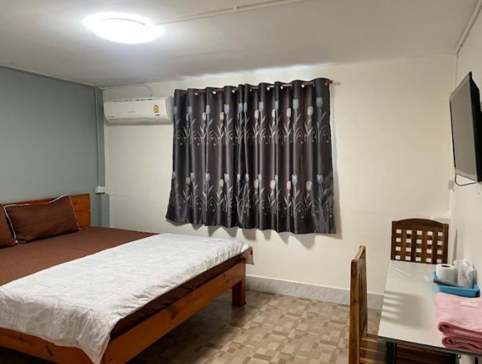 ピサヌロークにあるหอพักบ้านชูใจのベッドルーム1室(ベッド1台、黒いカーテン付)
