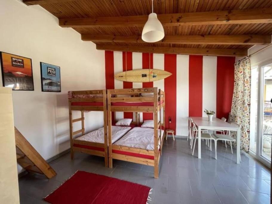 a bedroom with a bunk bed and a table at Da Silva Surfcamp 7 Bettzimmer mit Frühstück in Lourinhã