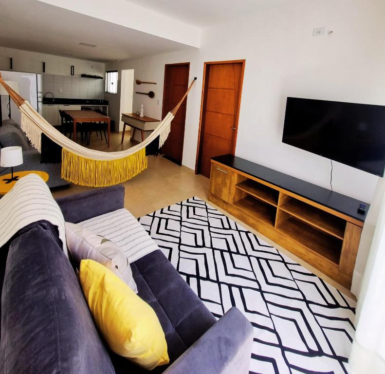 sala de estar con sofá y TV de pantalla plana en Casa.Km0 en Rio das Ostras