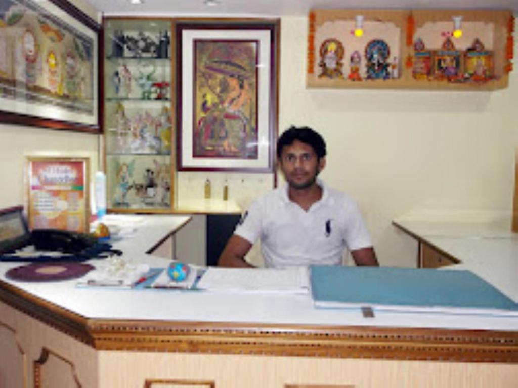 a man sitting at a counter in a room at Hotel Chancellor,Bhubaneswar in Bhubaneshwar
