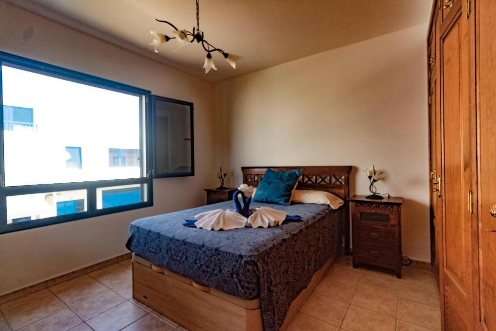 ein Schlafzimmer mit einem Bett und einem großen Fenster in der Unterkunft Casa Bianca Caleta De Famara in Famara