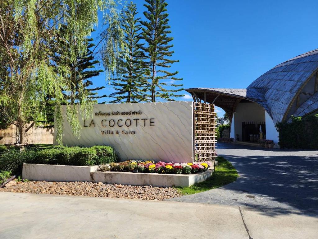 a welcome sign for a corporate building with flowers at LA COCOTTE VILLA & FARM KHAO YAI in Nong Sarai