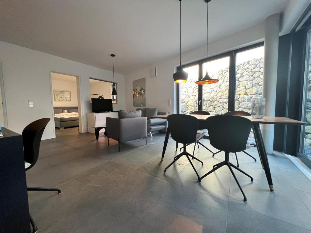 een eetkamer en een woonkamer met een tafel en stoelen bij Cosmopolitan in Überlingen