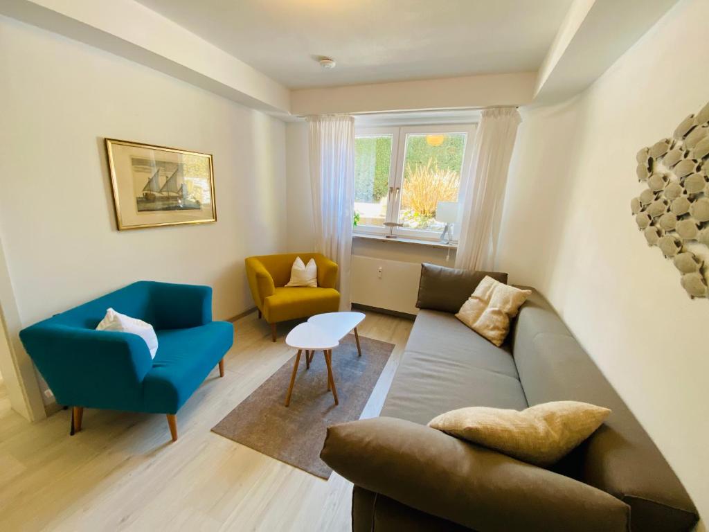 a living room with a couch and two chairs at Comfort-Appartment in Überlingen