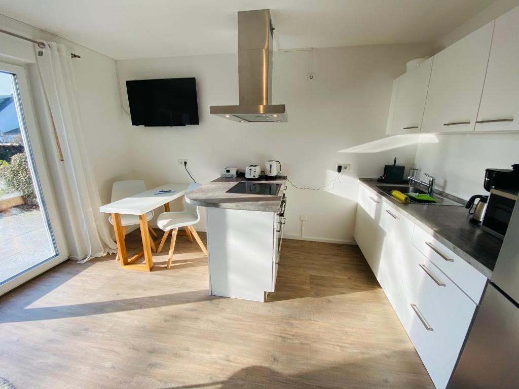 eine Küche mit weißen Schränken und einer Arbeitsplatte in der Unterkunft Apartment Relax in Überlingen Bodensee in Überlingen