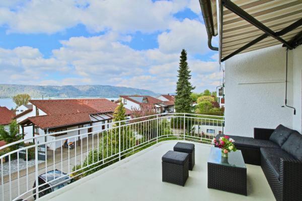 balcón con sofá y vistas a un edificio en Seeterrasse mit Seeblick, en Sipplingen