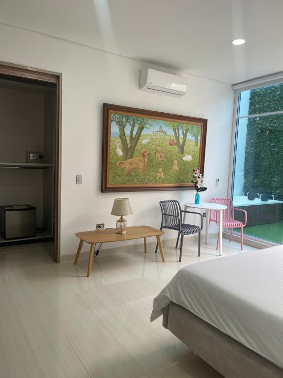 um quarto com uma cama, uma mesa e um quadro em Hotel Lotto Boutique em Cali