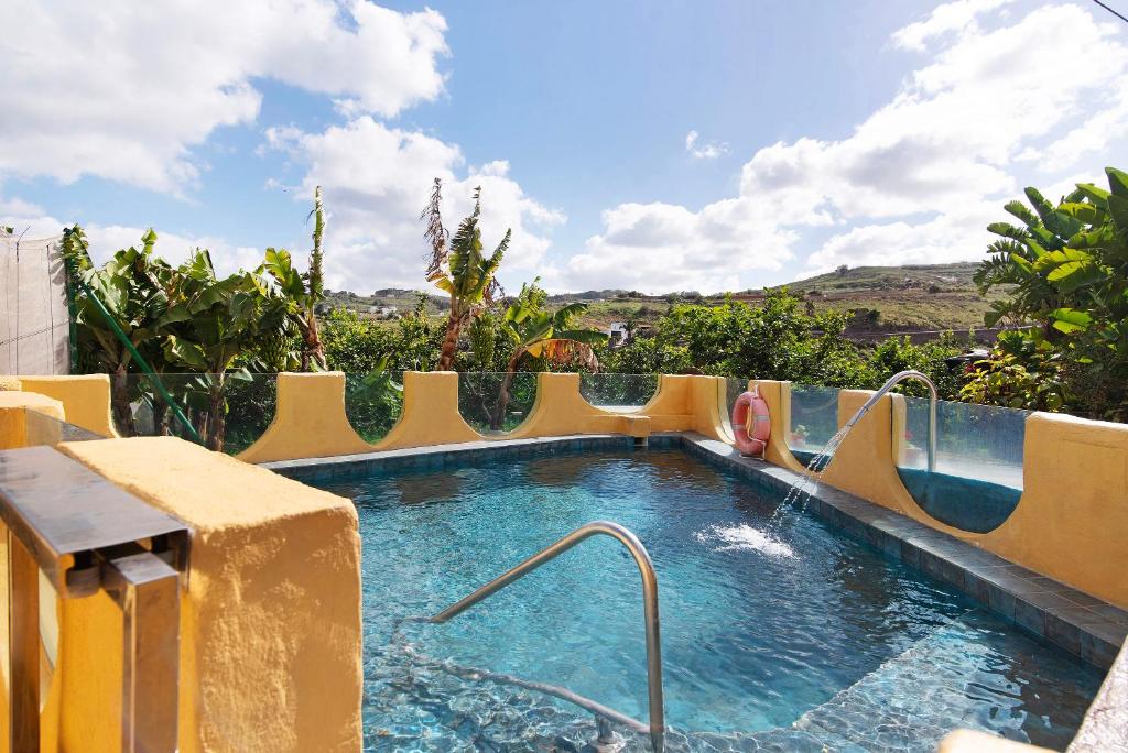 a pool with a water slide in a resort at Hogar vacacional Talu in Santa Maria de Guia de Gran Canaria