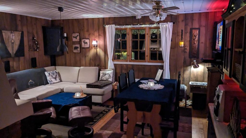 sala de estar con sofá y mesa en Turibu - cabin in a nice hiking and skiing area en Kongsberg