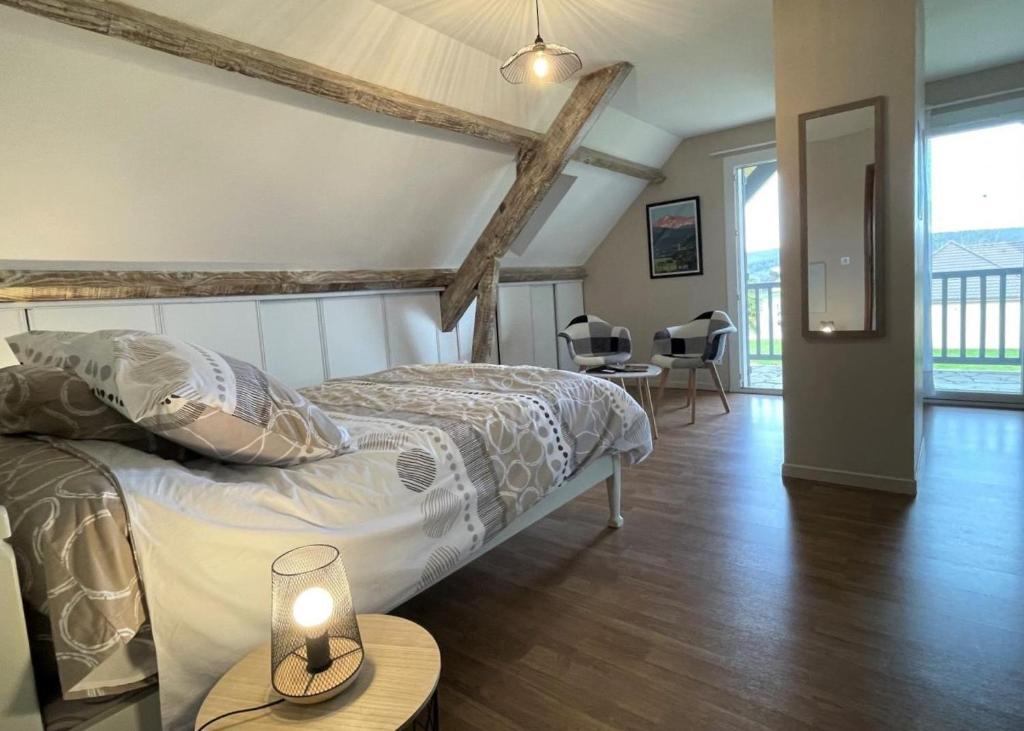 a bedroom with a bed and a table with a candle on it at Chez evelyne et titou in Bordères