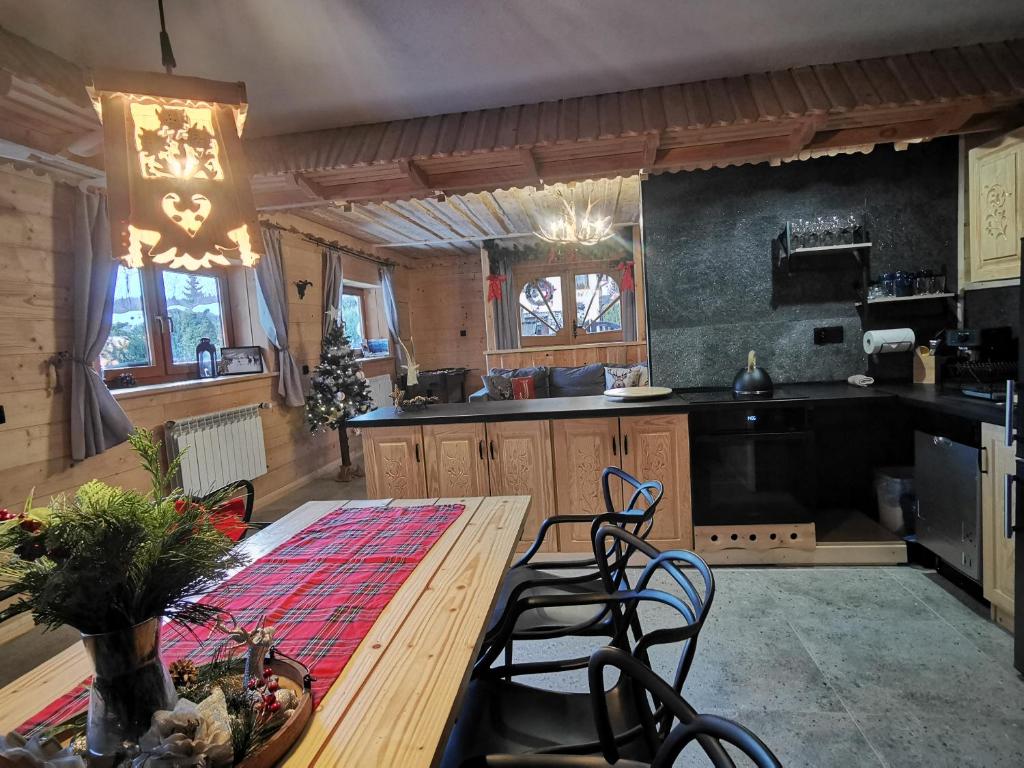 ビャウカにあるDomek do wynajęcia "Jodłowe Izby"の木製テーブルと椅子付きの広いキッチン
