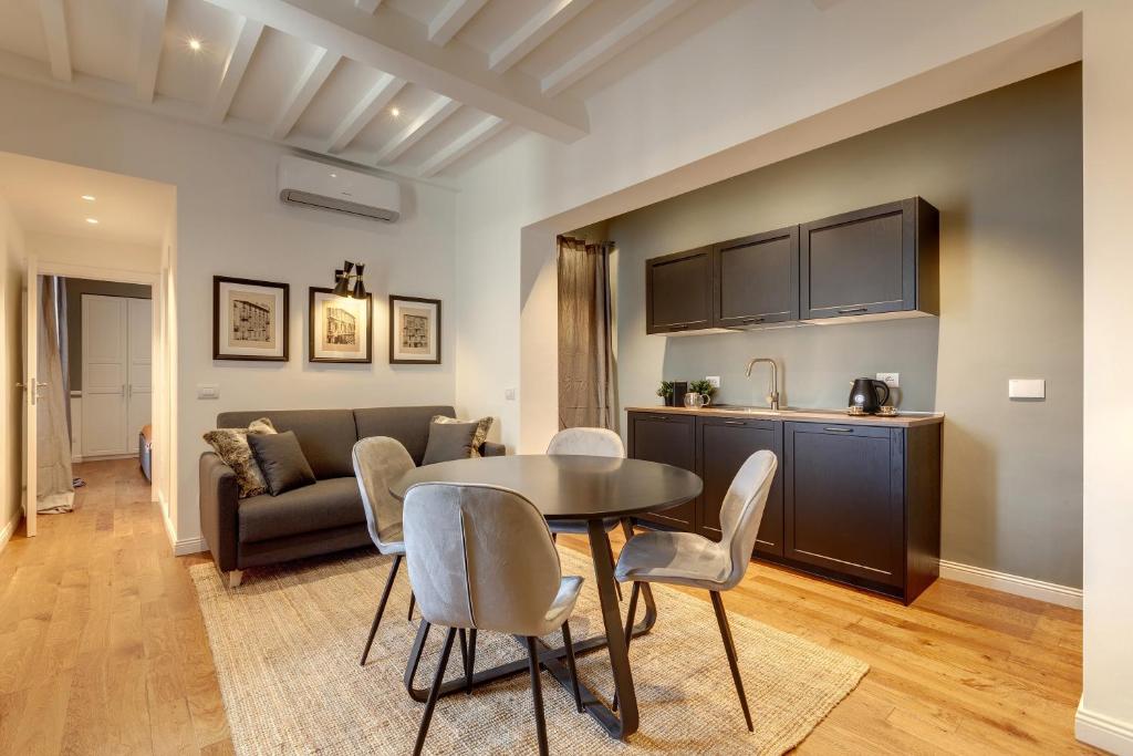 cocina y sala de estar con mesa y sillas. en Mamo Florence - La Badessa Apartment, en Florencia