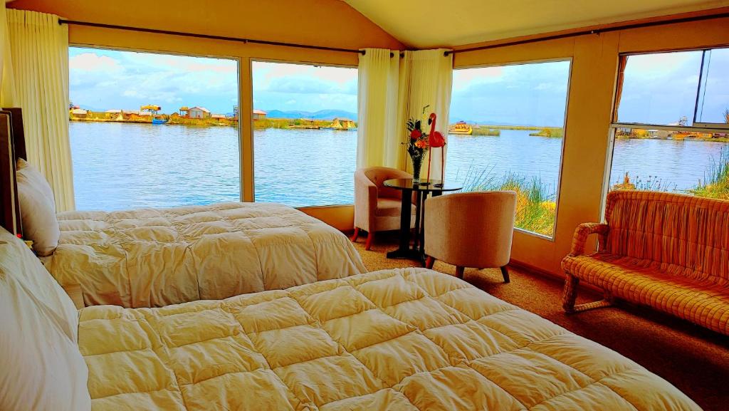 a bedroom with a bed and a view of the water at Uros Maya Lodge in Puno