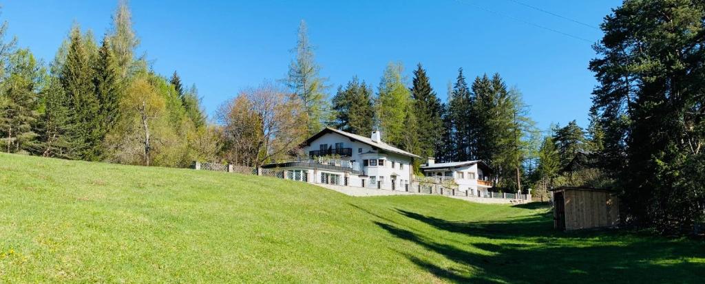 a large house on top of a grassy hill at Love the Alps Apartments in Reith bei Seefeld