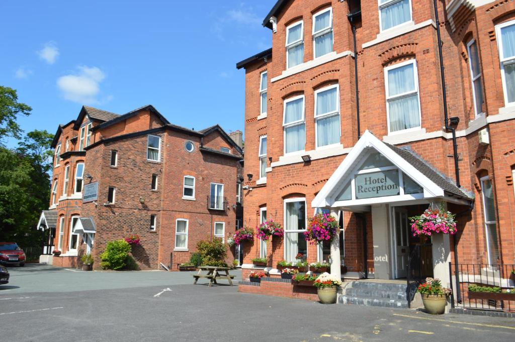 um grupo de edifícios de tijolos com flores numa rua em The Westlynne Hotel & Apartments em Manchester