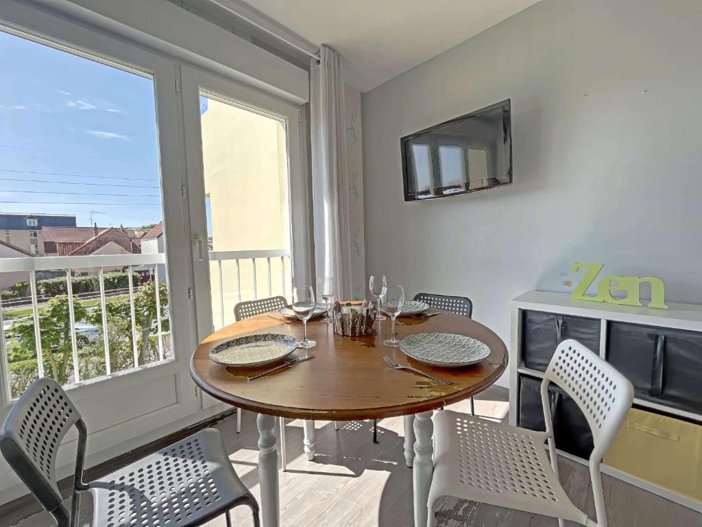 une salle à manger avec une table et des chaises et une fenêtre dans l'établissement Studio 27m² proche mer avec balcon, parking et ascenseur - tout confort ! - FR-1-646-16, à Berck-sur-Mer