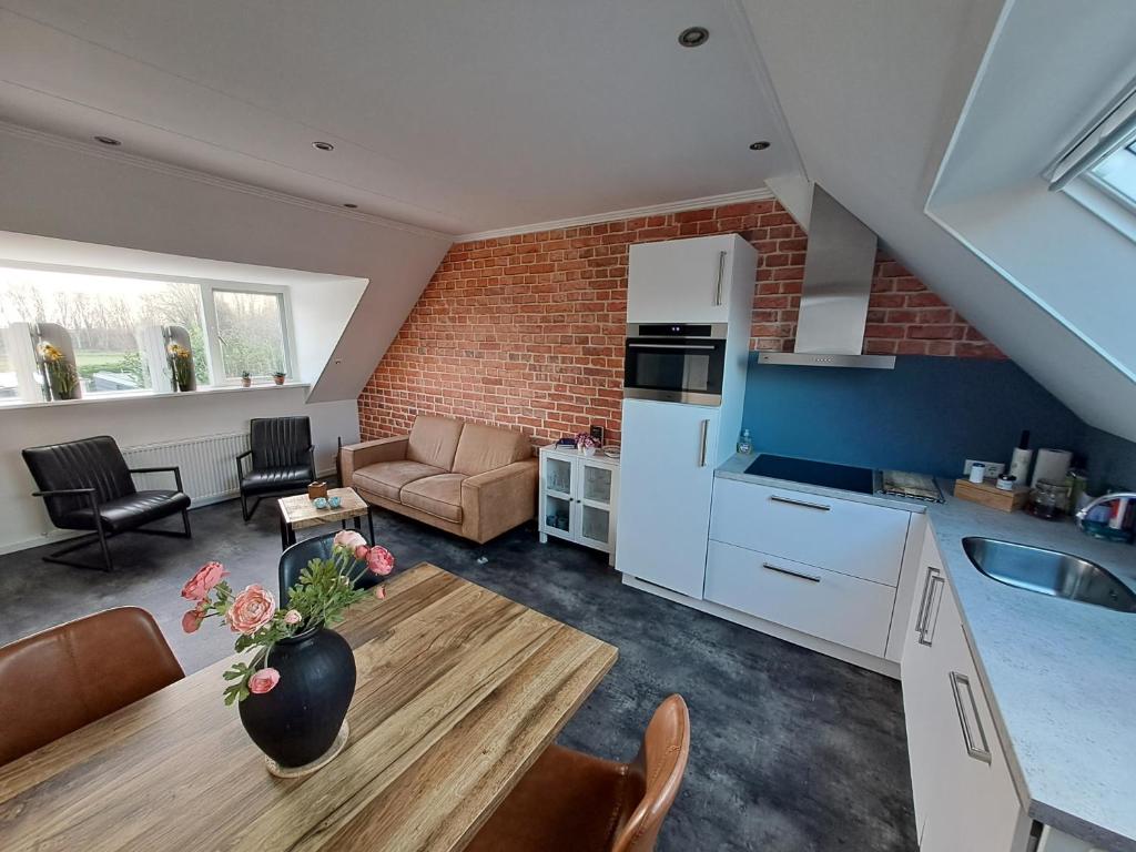 a kitchen and living room with a couch and a table at de Bloemenhof in Ouddorp