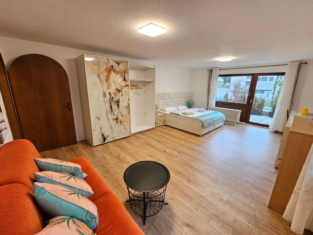 ein Wohnzimmer mit einem orangefarbenen Sofa und einem Bett in der Unterkunft schöne Wohnung am Georgenberg in Reutlingen