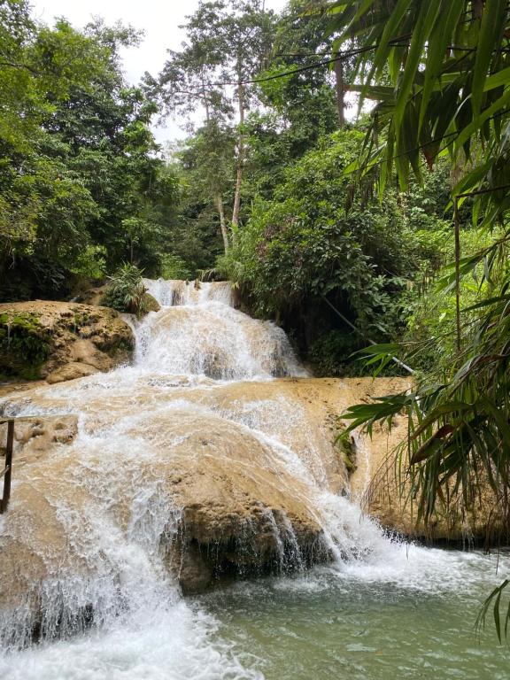 une cascade au milieu d'une piscine d'eau dans l'établissement Pù luông homestay Ngọc Dậu, à Thanh Hóa