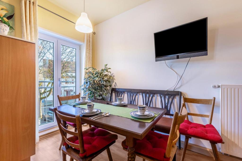 a dining room with a table and chairs and a television at Ferienwohnung Links in Welden