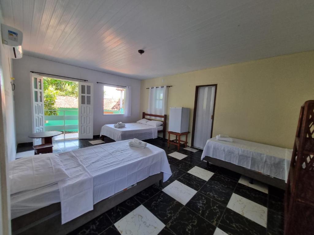 Cette chambre comprend 2 lits et une fenêtre. dans l'établissement Pousada iakã, à Cairu