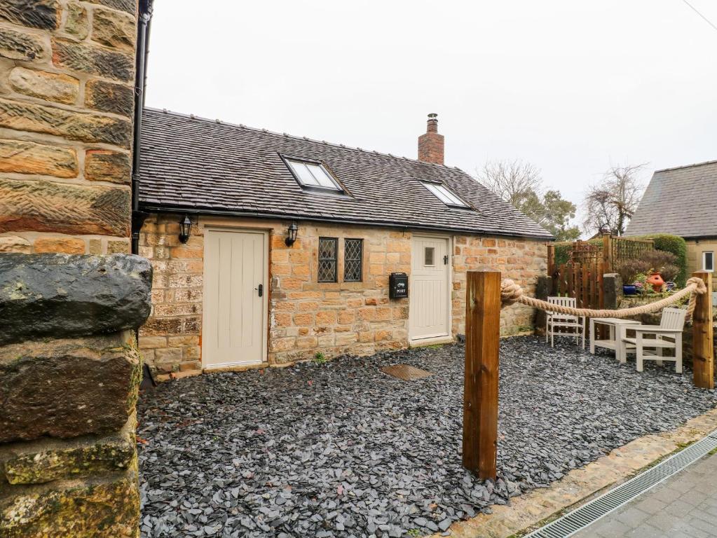 a stone house with a bench in front of it at 33 Main Road in Alfreton