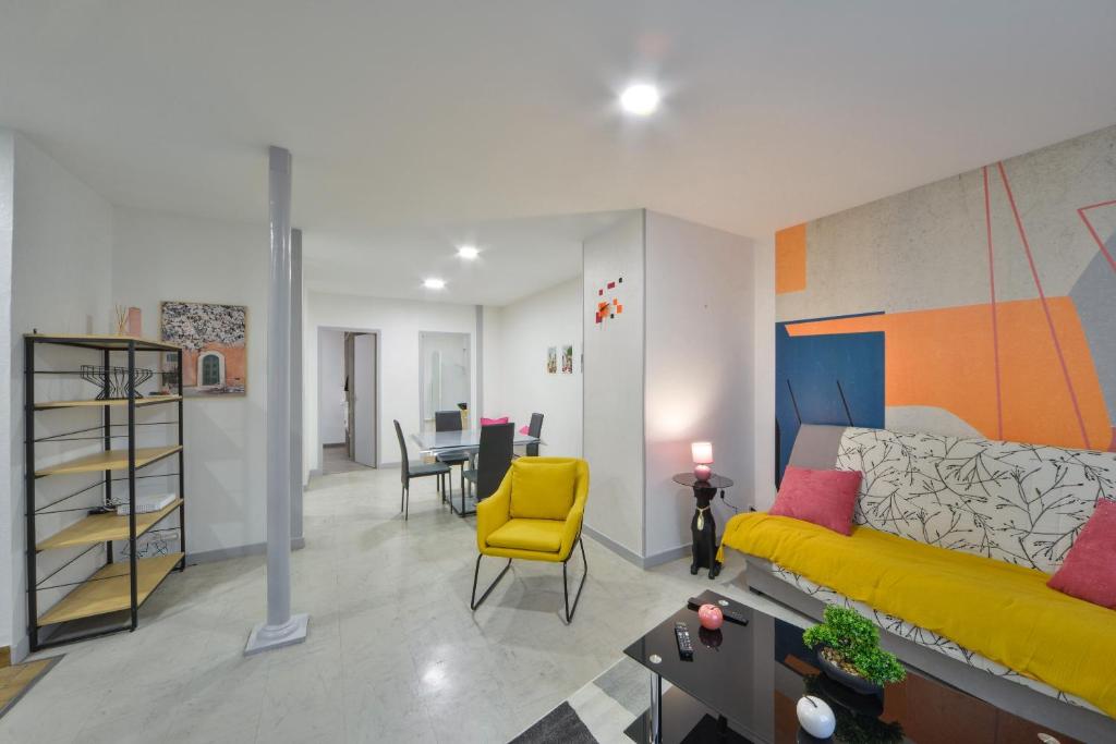 un salon avec un canapé jaune et une table dans l'établissement L'Appart de Mimie - Proche des Marais de Bourges, à Bourges