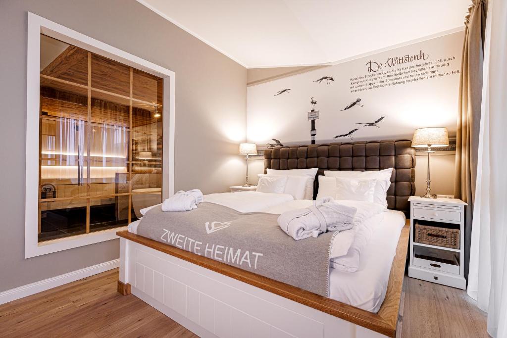 a bedroom with a large bed and a window at Hotel Zweite Heimat in Sankt Peter-Ording