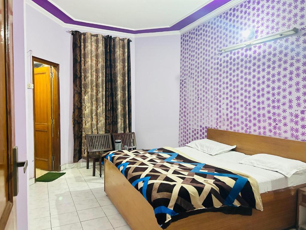 ein Schlafzimmer mit einem Bett und einer lila Wand in der Unterkunft Sunrise hotel in Jalandhar