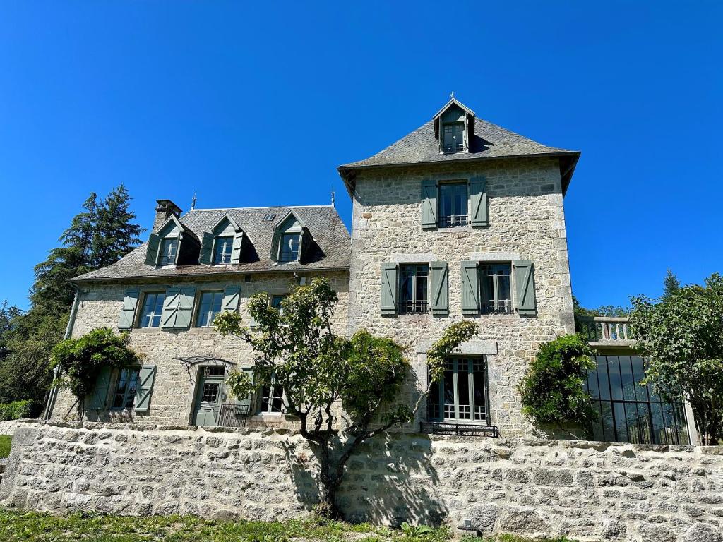 Le Manoir du Rigouneix au coeur de la nature, calme-sauna-dîner maison في Saint-Angel: مبنى حجري قديم عليه برج