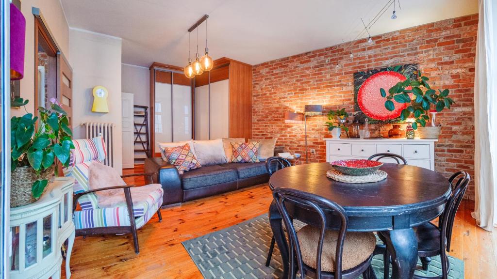 a living room with a table and a brick wall at Apartamenty Sun & Snow Old Town Gdańsk in Gdańsk