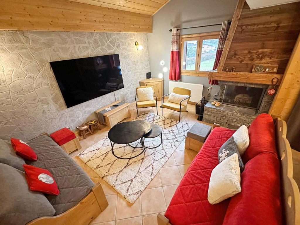 un salon avec un canapé rouge et une télévision dans l'établissement Duplex spacieux avec terrasse, piscine couverte et cheminée à Samoëns - FR-1-624-9, à Samoëns
