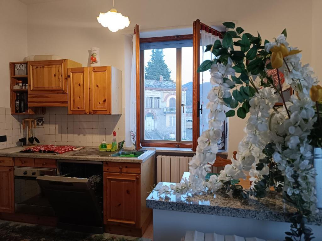 a kitchen with a kitchen counter with a window at Grazioso bilocale Merlino, luminoso con vista Santuario, wifi in Giaveno