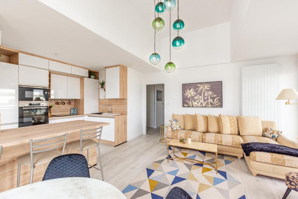 un salon avec un canapé et une table dans l'établissement Le Majestic by Plaza - Proche Disneyland Paris, à Chessy