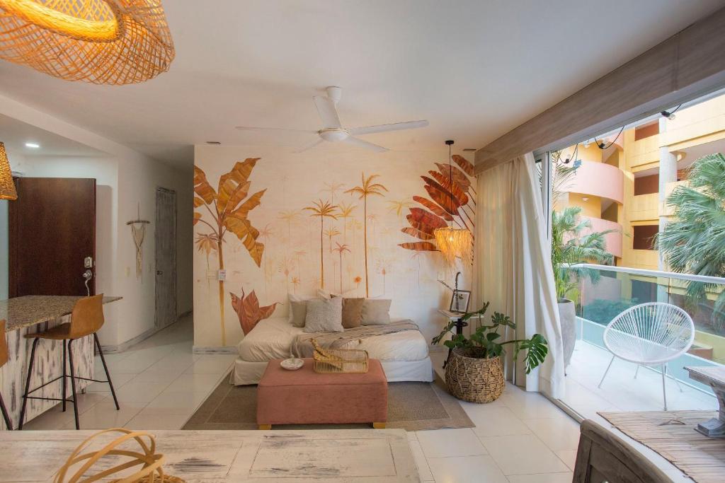 a living room with a couch and palm trees on the wall at Condominio frente al mar con acceso directo a la playa Morros 922 in Cartagena de Indias