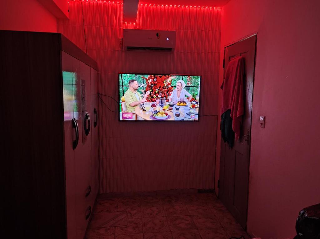 un soggiorno con TV su una parete rossa di Casa a São Luís