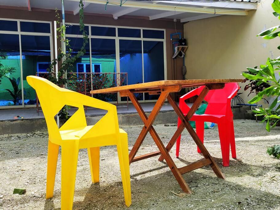 Feydhoo的住宿－Veyodhoshuge, S.Feydhoo, Addu city，四把五颜六色的椅子围着木桌