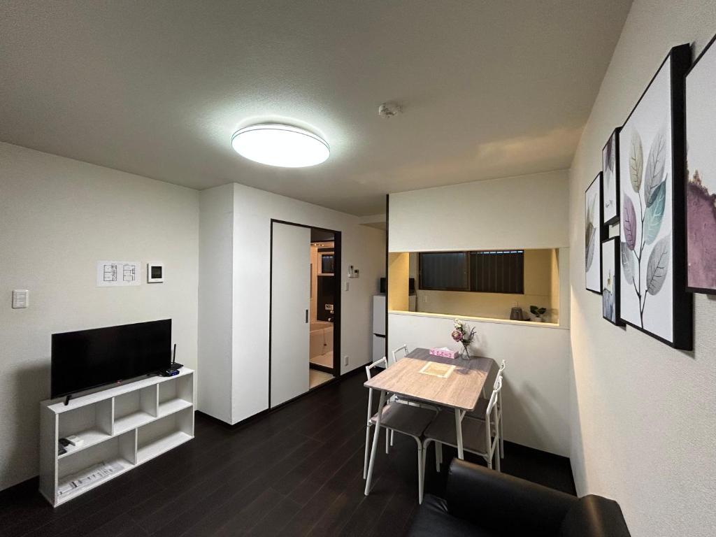 una pequeña sala de estar con mesa y TV en 舒心云舍, en Osaka