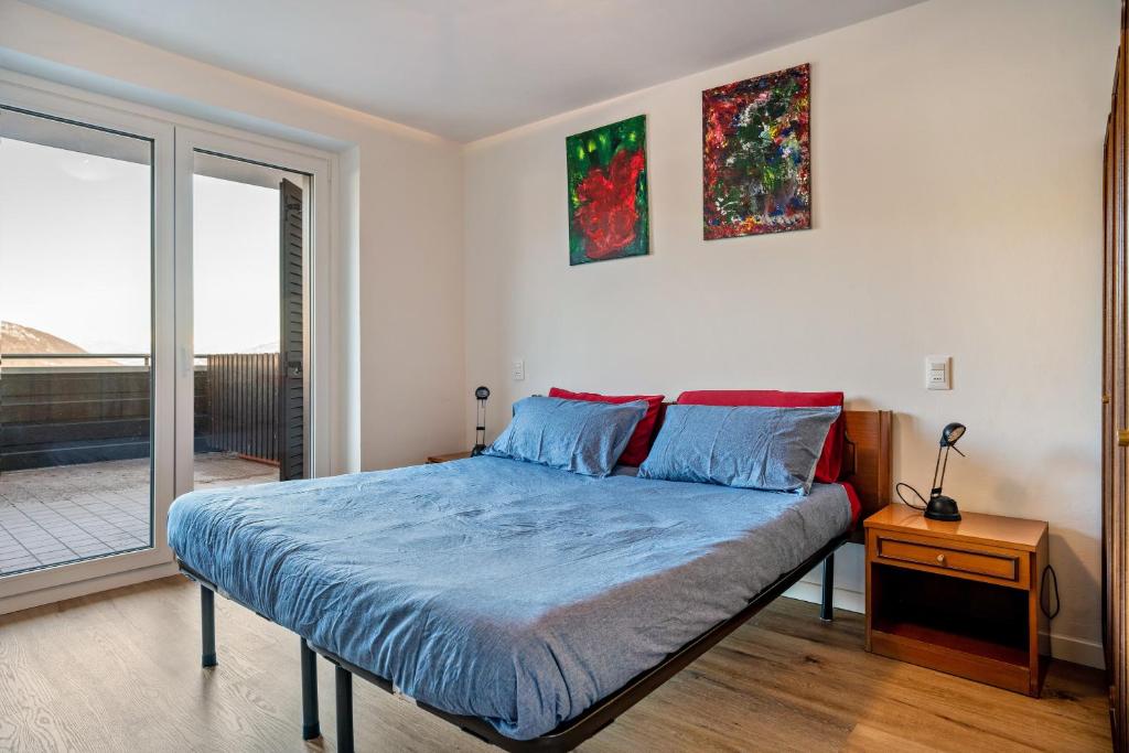 a bedroom with a bed with blue sheets and a window at Appartamento Polsa 4 in Brentonico