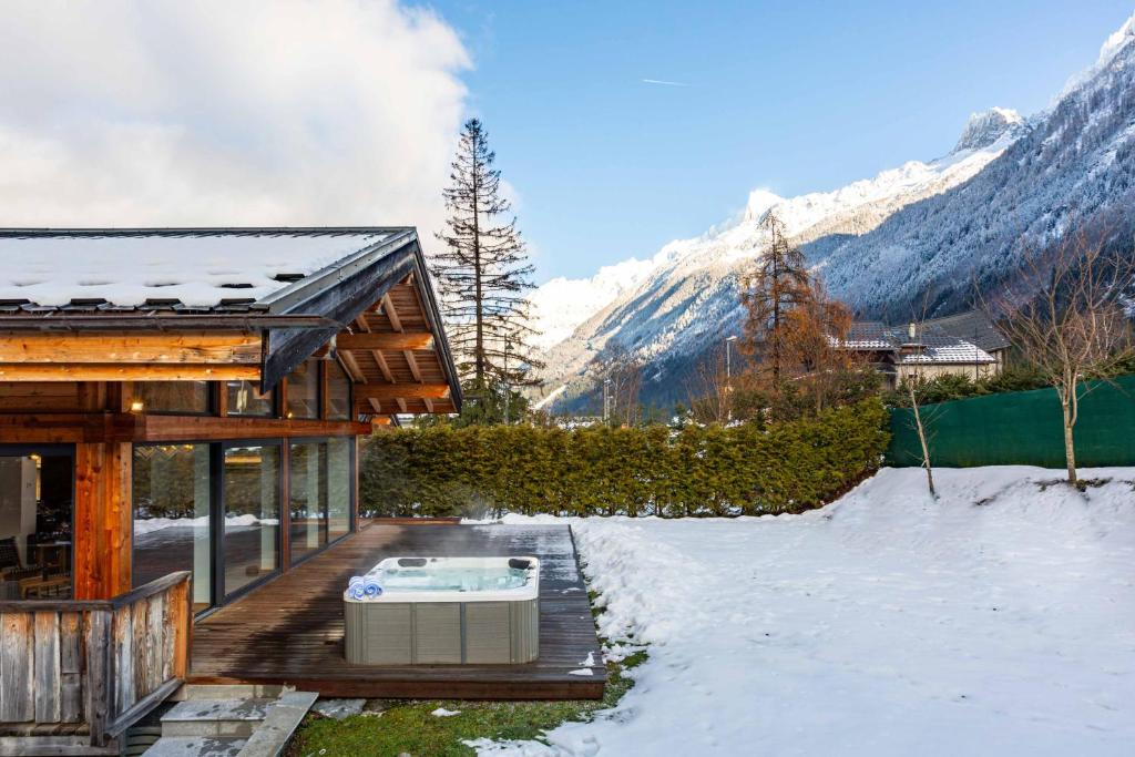 une maison avec un bain à remous dans la neige dans l'établissement Chalet Gloribel, à Chamonix-Mont-Blanc