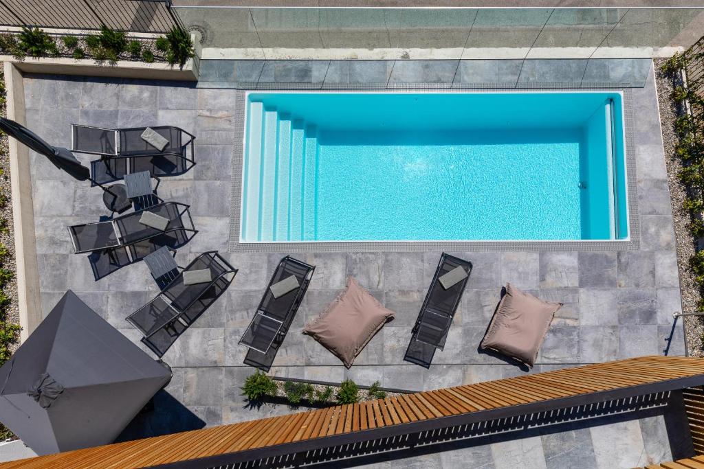 an overhead view of a swimming pool with chairs and a table at Köfele Lodge Agnes in Parcines