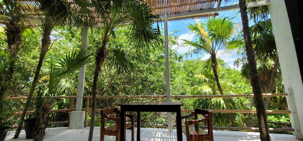 a table and chairs in a room with palm trees at Casa Ambar Tulum - Great Location in Tulum